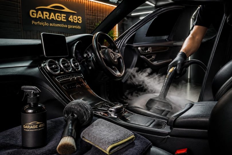 Técnico realizando higienização interna de carro com equipamentos profissionais em oficina em Moema