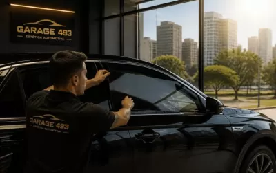 Técnico aplicando película nos vidros de um carro estacionado em oficina na Zona Sul de São Paulo