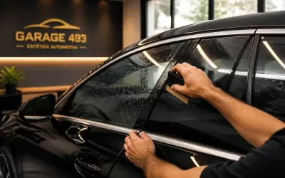 Técnico aplicando película automotiva no vidro de um carro em oficina em Moema