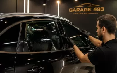 Técnico aplicando película ceramic em veículo estacionado em oficina em Moema